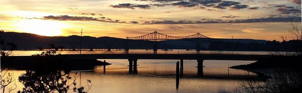 Sun setting with reflection and bridges in foreground